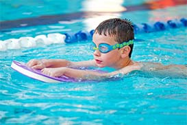 a boy swimming with a floatation device