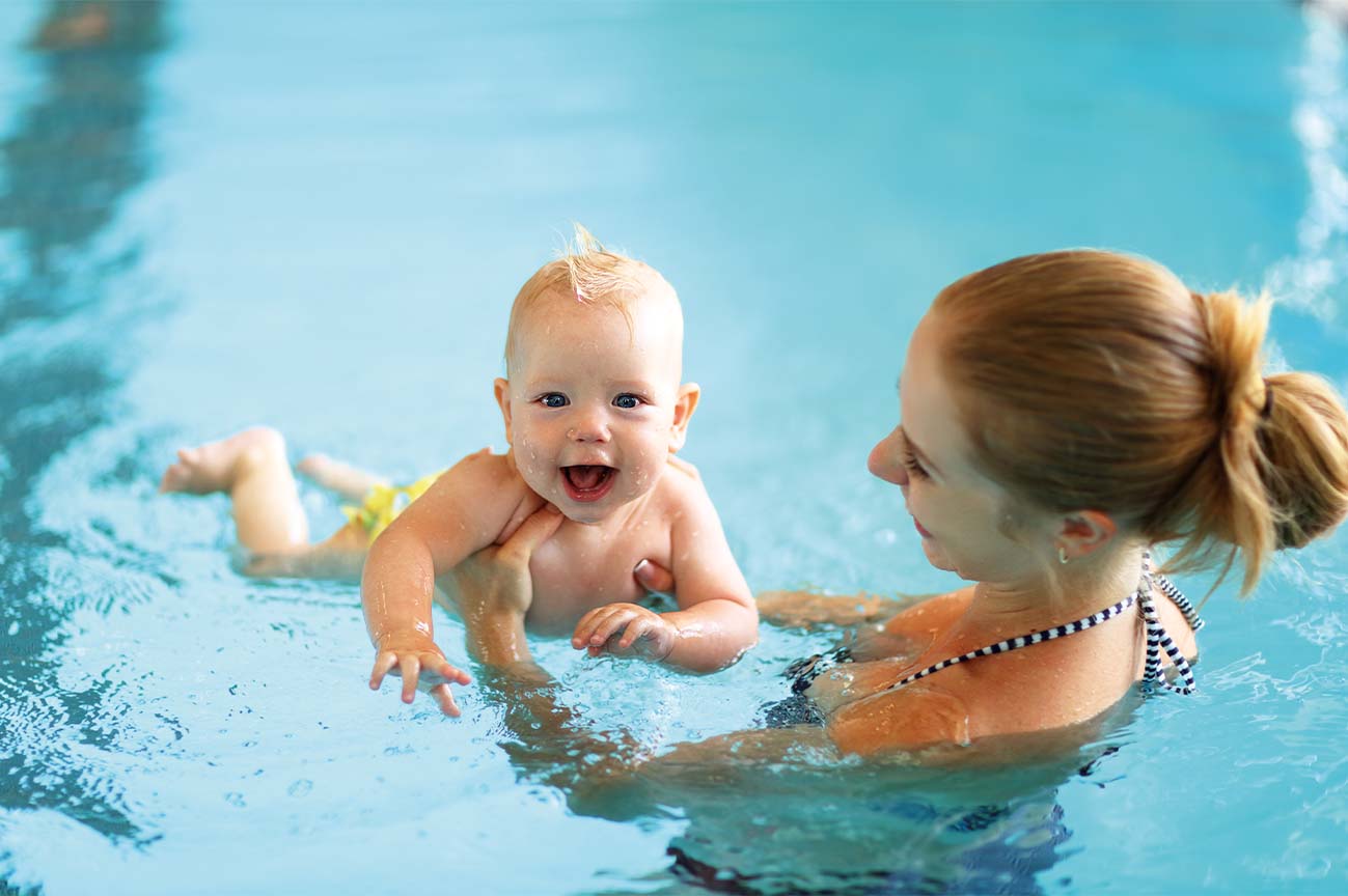 a woman and a baby in a swimming pool