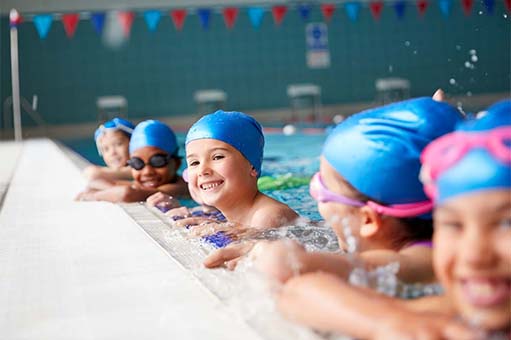 group of children at edge of swimming pool in a lesson